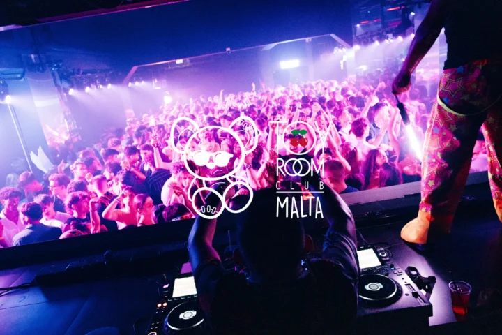 DJ booth view of Toy Room Super Club Night in Malta, with a packed crowd, purple club lights and the Toy Room logo over the image.