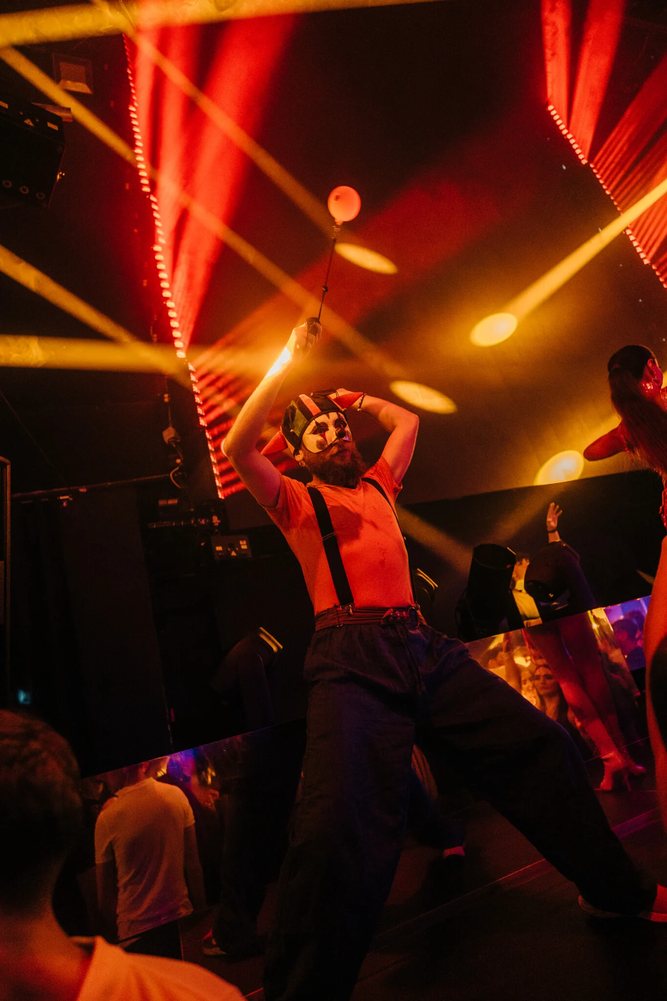 Masked performer entertaining the crowd under red and gold lights at Toy Room Super Club Night in Malta