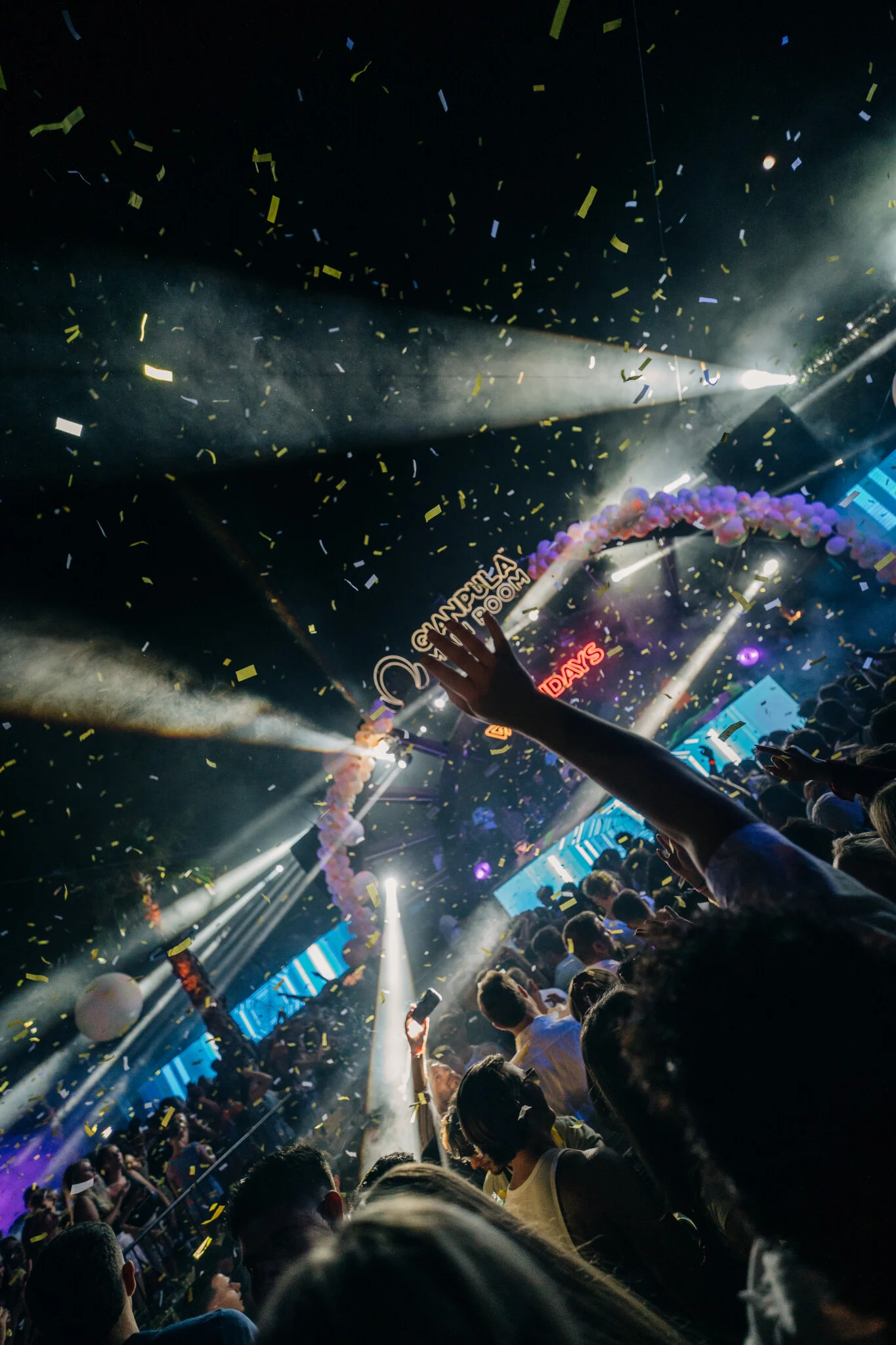 Confetti falling over the crowd at Gianpula Main Room Club Night in Malta, with bright stage lights cutting through the packed venue.