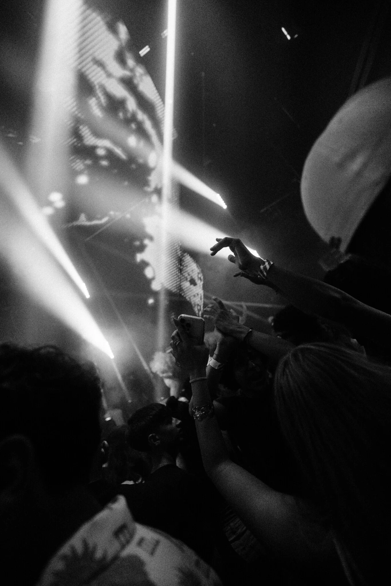 Girls and lads holding up phones and hands beneath bright stage lights at Toy Room Super Club in Malta