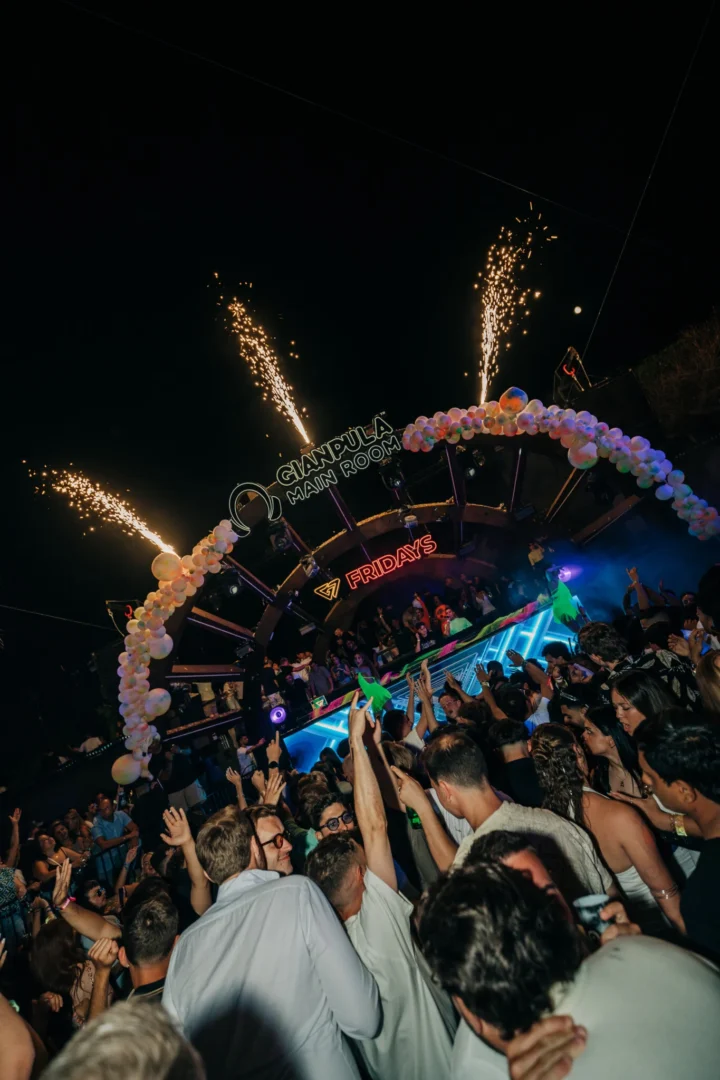 Crowd packed in front of the stage at Gianpula Fridays Club Night in Malta, with fireworks above the DJ booth and hands raised in the air.