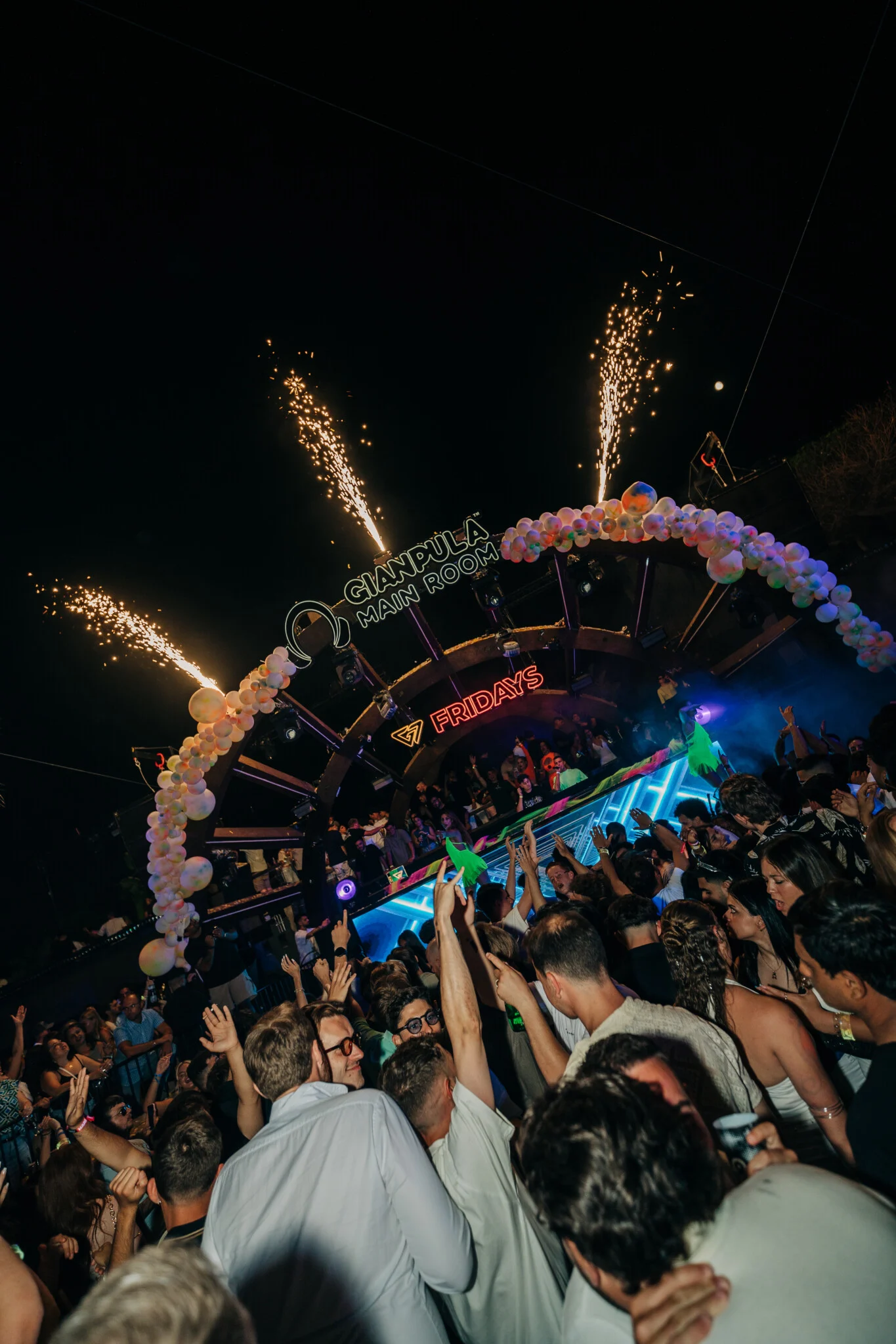 Crowd packed in front of the stage at Gianpula Fridays Club Night in Malta, with fireworks above the DJ booth and hands raised in the air.