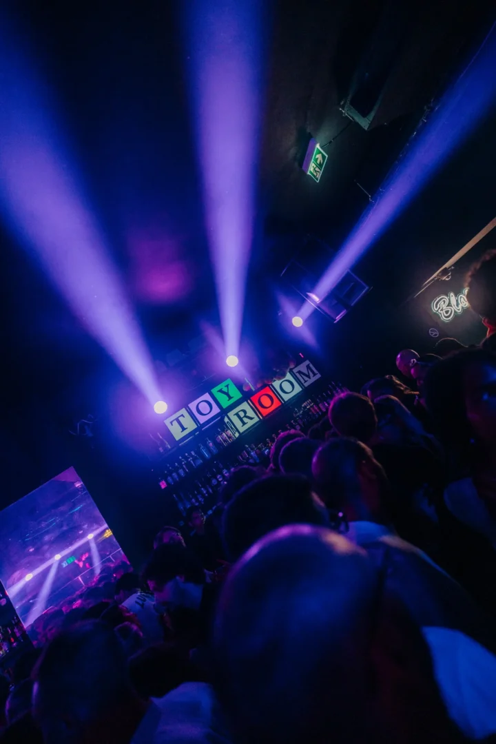 Packed crowd inside Toy Room Super Club Night in Malta with purple spotlights above the bar and Toy Room sign in view