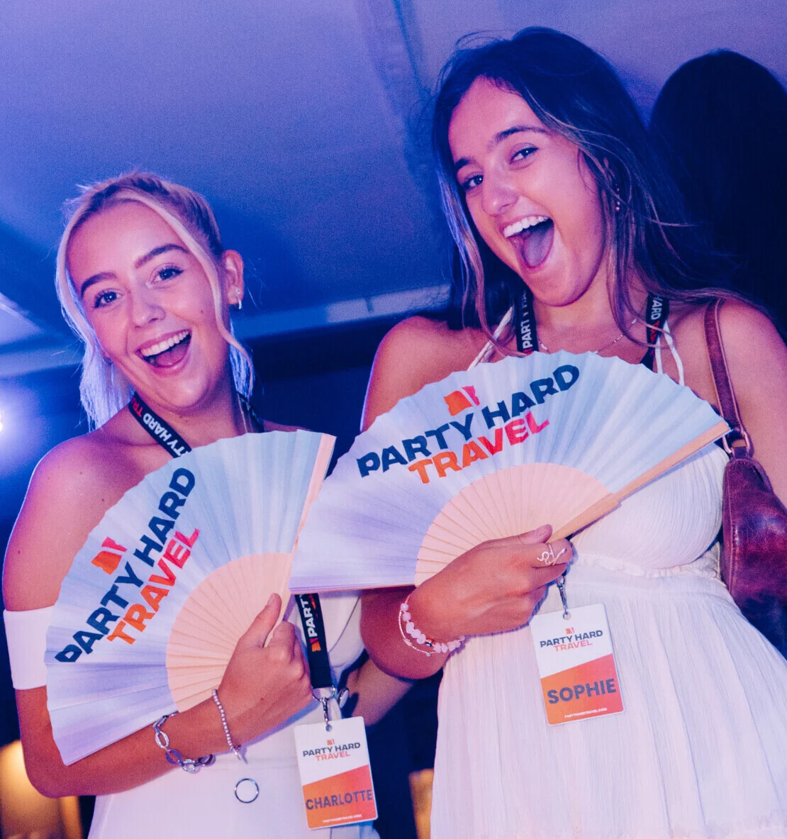 Agenda White Party in Kavos with two Reps holding Party Hard Travel fans, all smiles under club lights