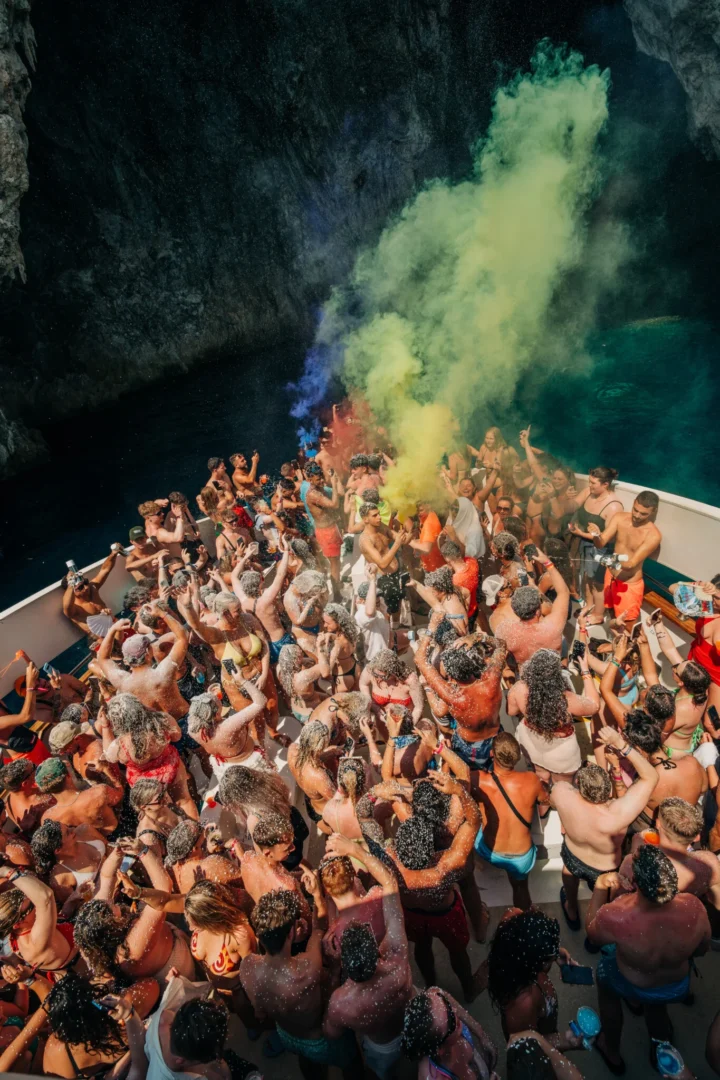 Lads and girls erupt on the Kavos boat party as foam and coloured smoke fill the deck inside a hidden sea cave