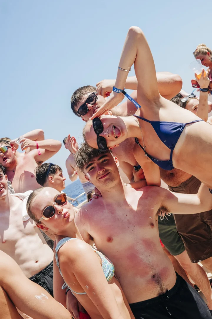 Lads and girls pose for the camera on the Kavos Booze Cruise, smiling, pulling faces and fully in party mode at sea
