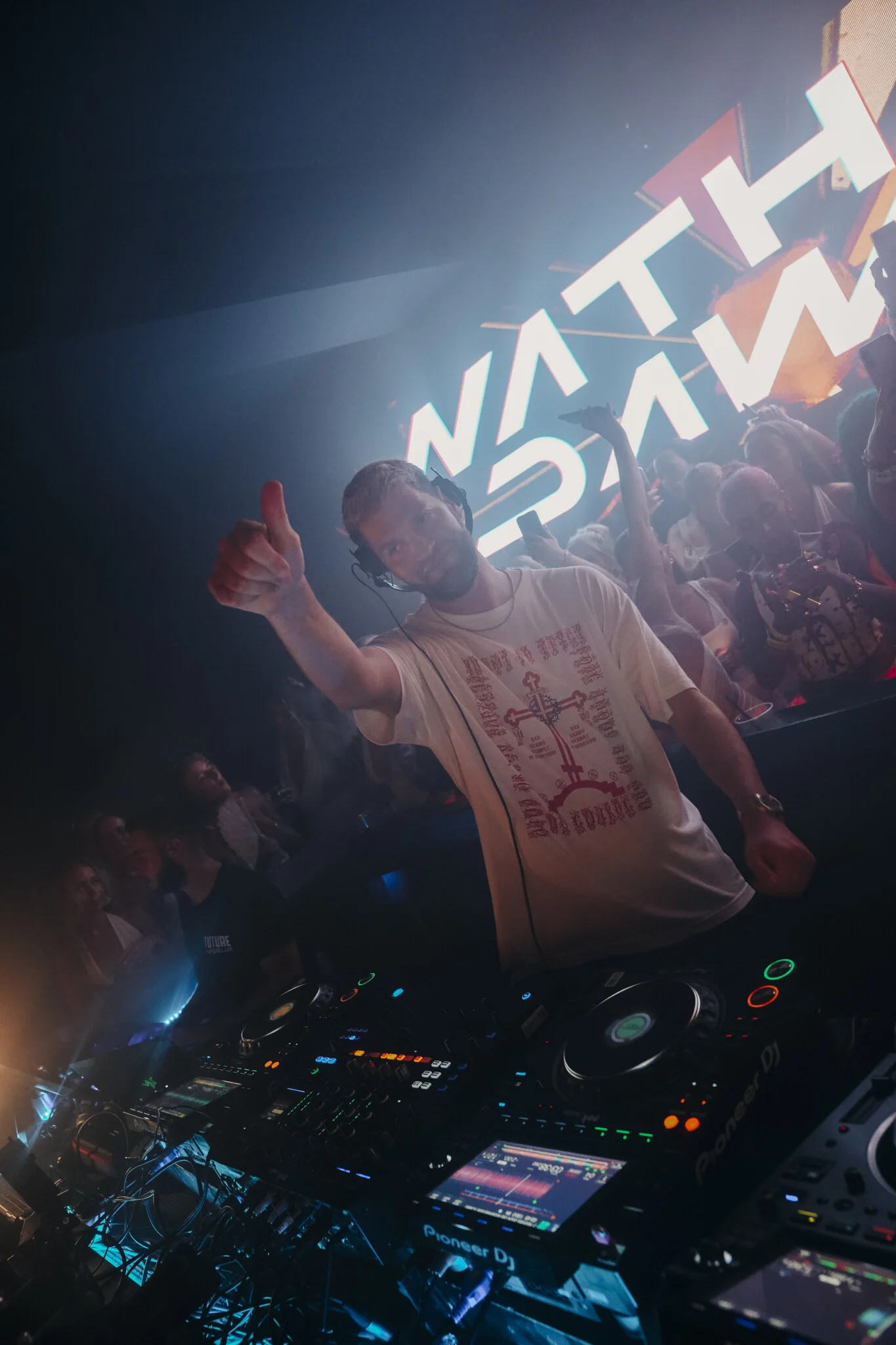 Nathan Dawe on the decks at Agenda White Party, Kavos, locking in the crowd as hands go up and the room hits full throttle