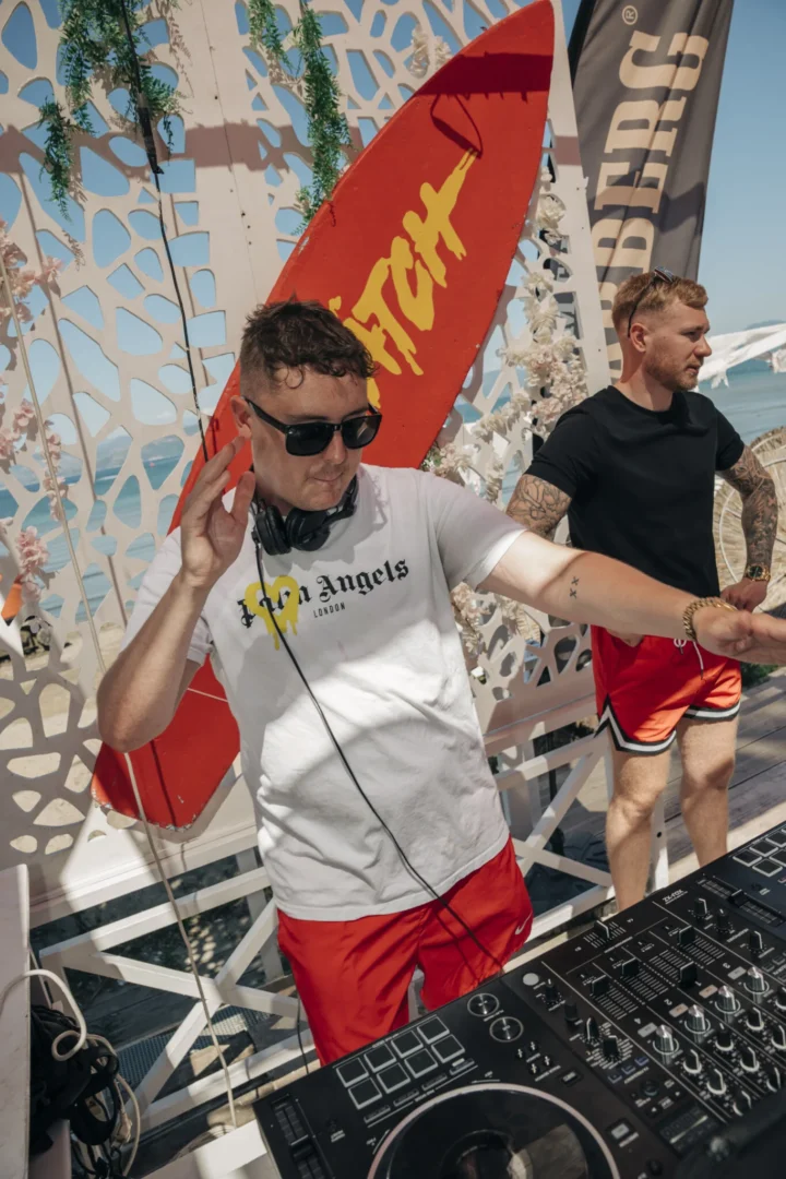 DJ spinning upbeat daytime tracks at Baywatch Pool Party in Kavos as the crowd gears up for another high energy poolside session