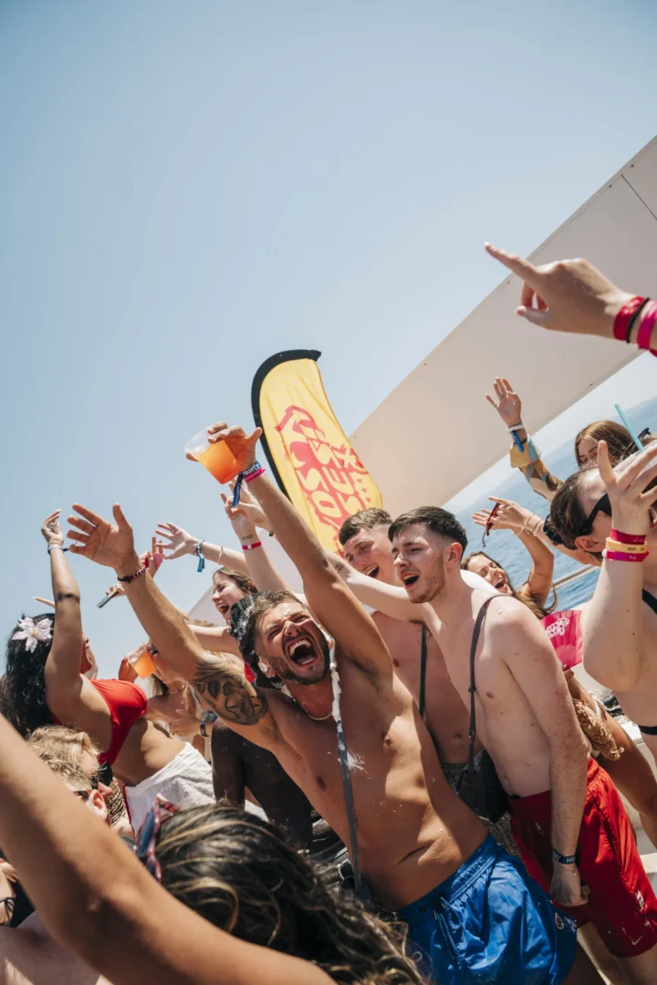 Lads and girls throw their hands up on the Kavos boat party, drinks flying as the deck party hits top gear