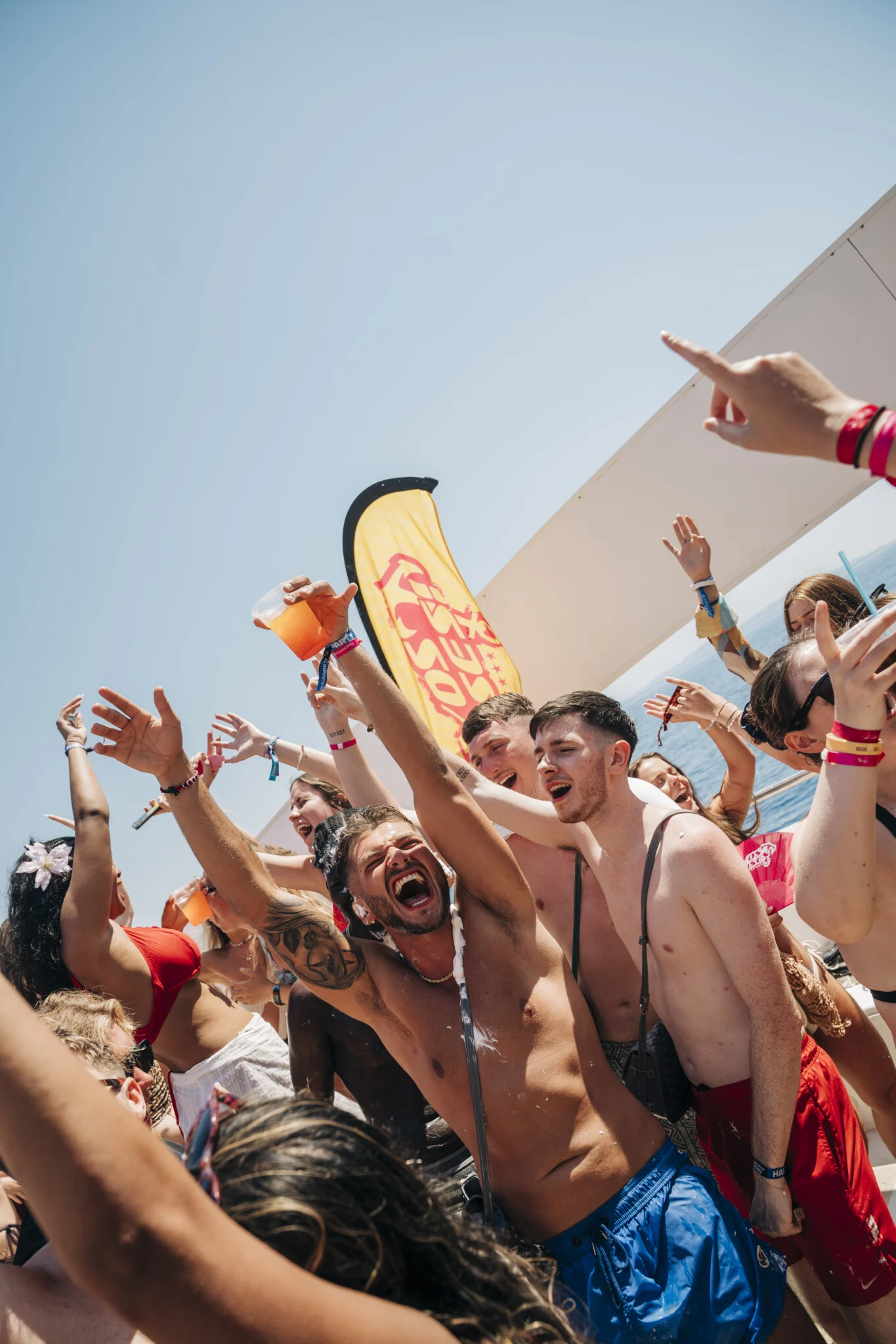 Lads and girls throw their hands up on the Kavos boat party, drinks flying as the deck party hits top gear