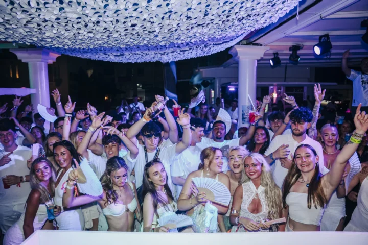 Agenda White Party in Kavos packed wall to wall, hands up, fans waving and drinks flowing under bright club lights