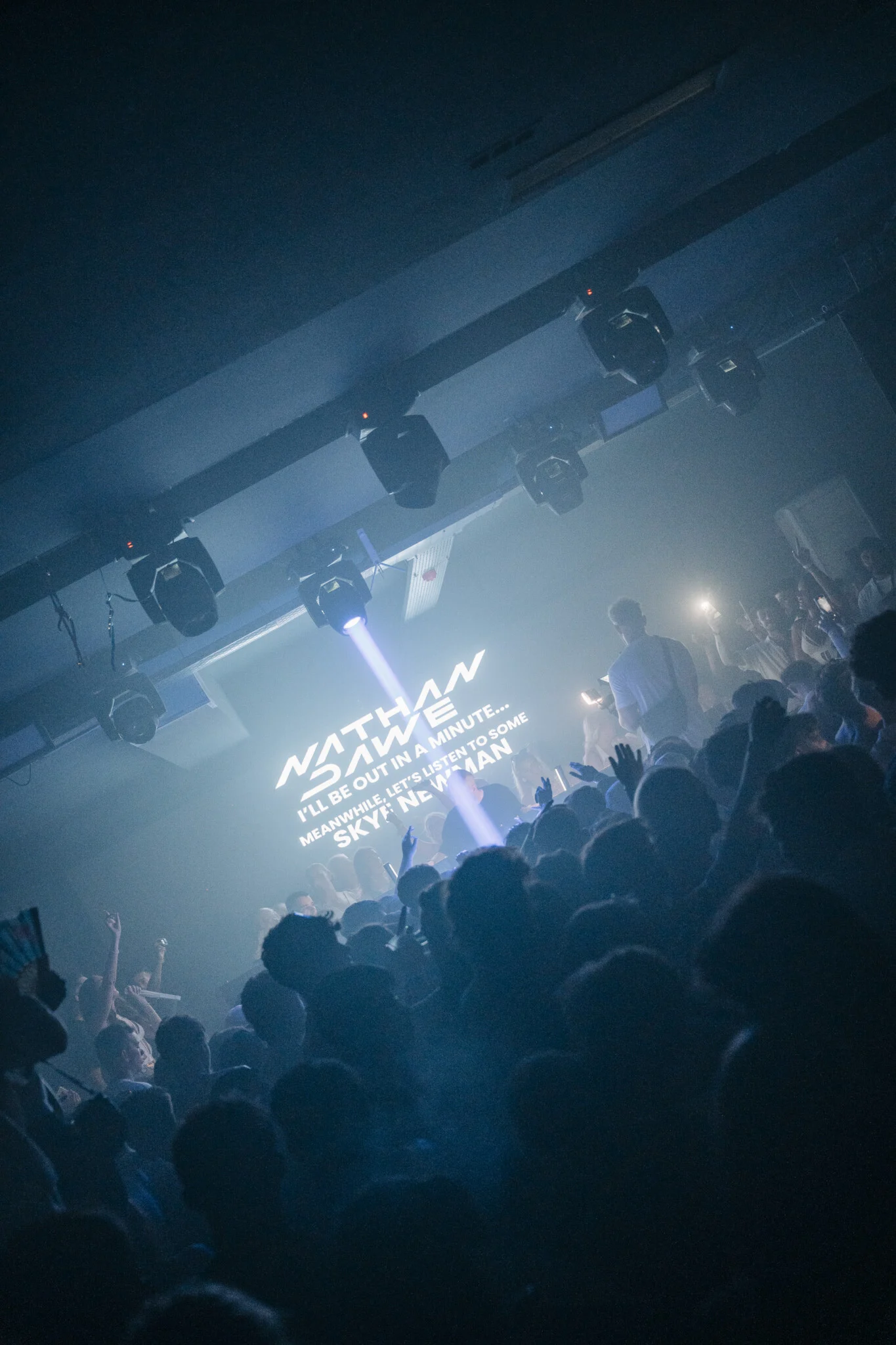 Agenda White Party in Kavos as laser lights cut through smoke, DJ on stage and a packed crowd jumping with hands in the air