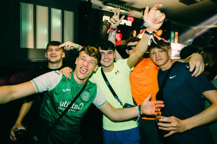 Group of lads celebrating at the After Party Pass Croatia event inside Bacvice Club in Split with drinks, wristbands and hands in the air