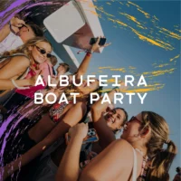 Group of girls partying on the Albufeira Boat Party under clear blue skies with phones raised and music playing on deck