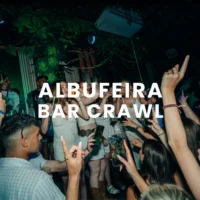 Partygoers enjoying the Albufeira Bar Crawl in a busy nightclub, dancing and holding drinks under colourful club lights
