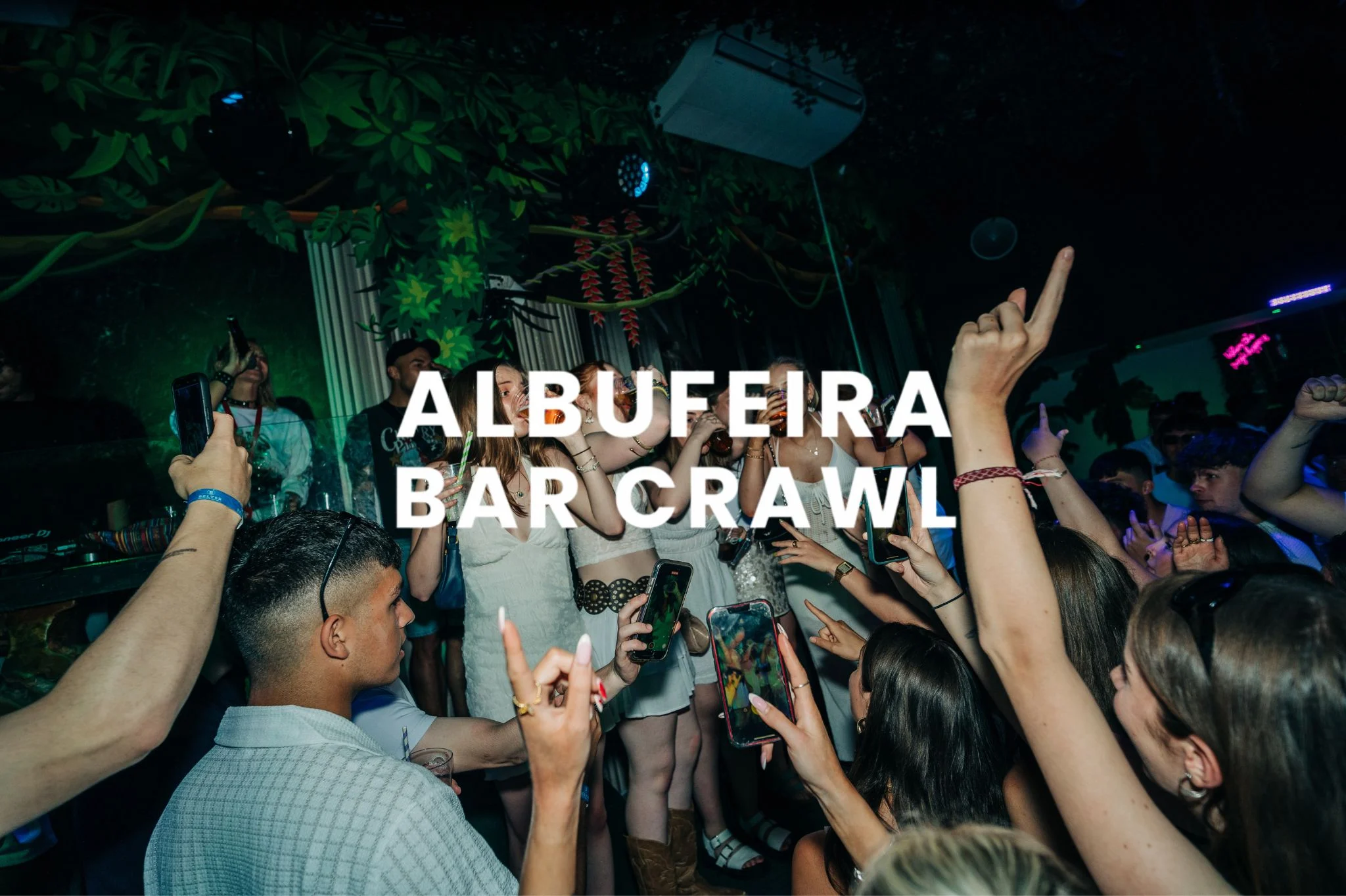 Partygoers enjoying the Albufeira Bar Crawl in a busy nightclub, dancing and holding drinks under colourful club lights
