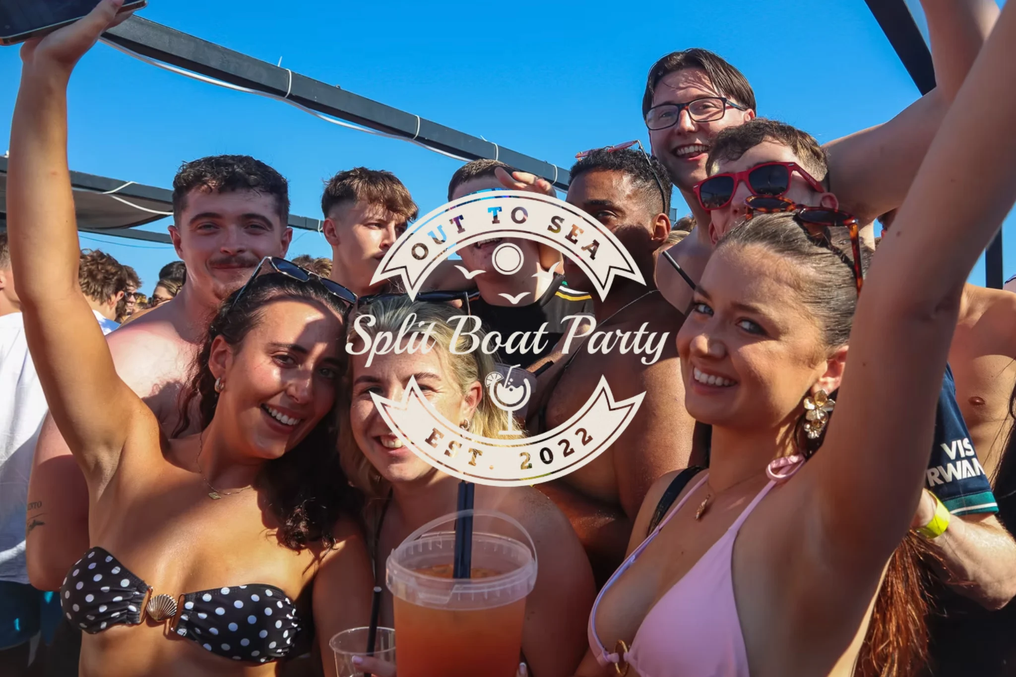 Group of girls and lads enjoying the Out to Sea Split Boat Party booze cruise in Croatia with drinks, swimwear and sunshine on deck