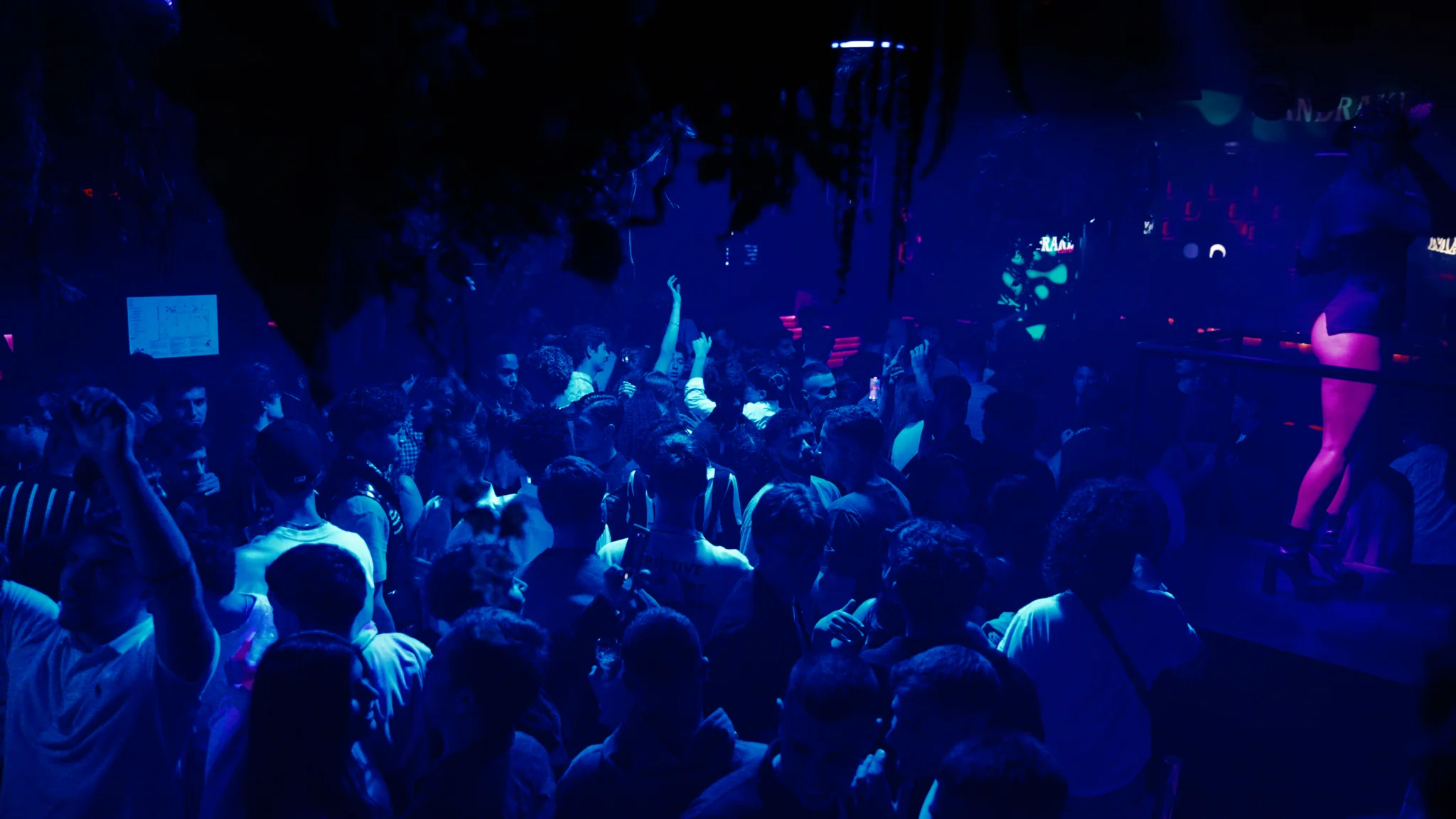 Packed dancefloor on the Barcelona nightlife tour at Opium nightclub with hands in the air, deep blue lights and full crowd energy all night long