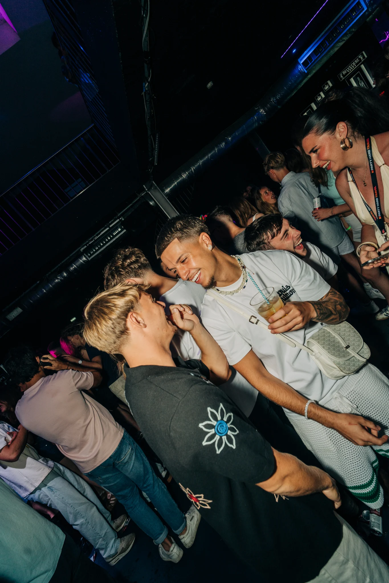 Lads chatting and laughing at the House of Tech event in Albufeira while the nightclub crowd socialises around them