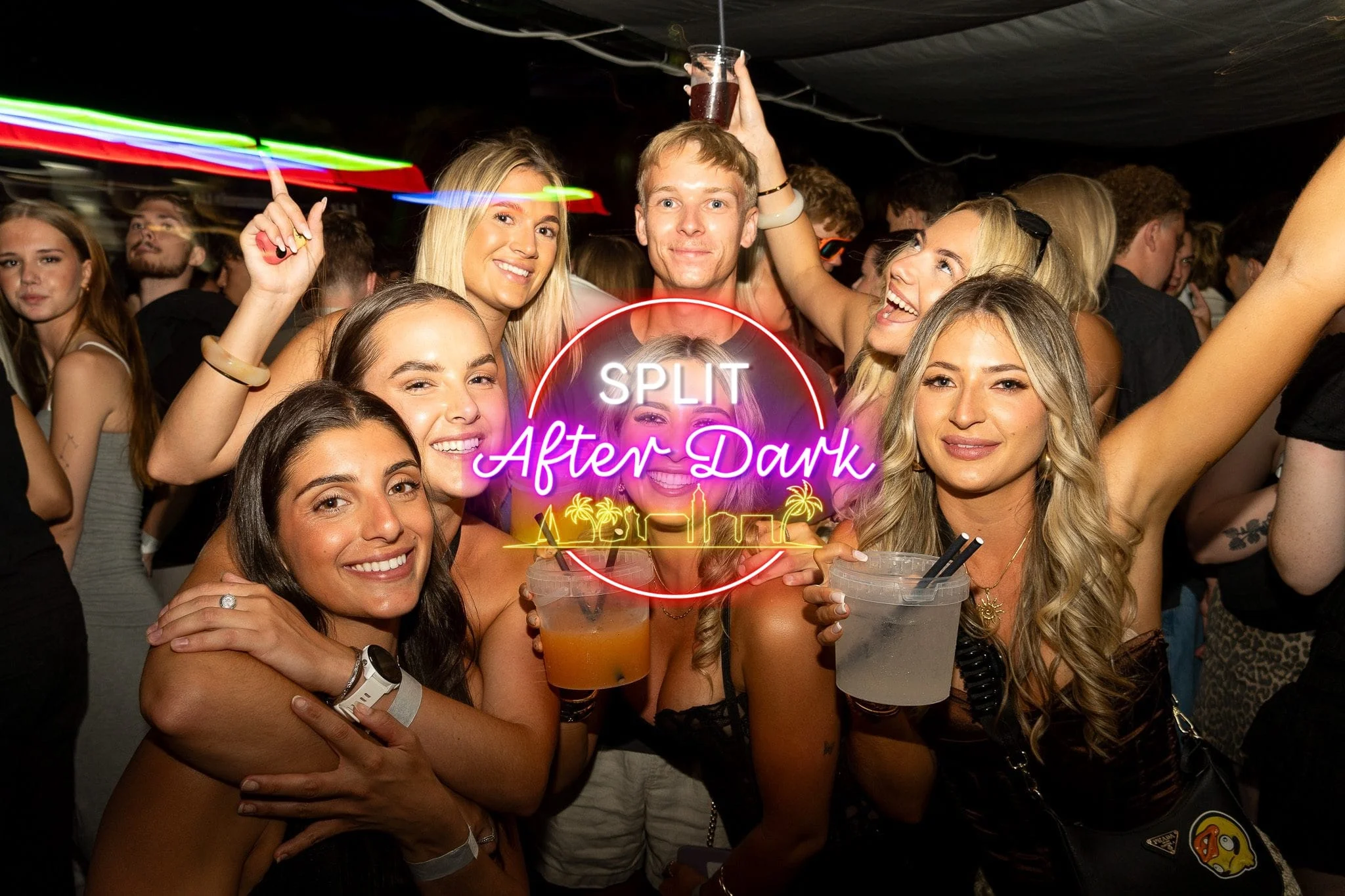Girls and lads enjoying Split After Dark in Croatia, holding drinks and posing together beneath the glowing event logo in a packed club.
