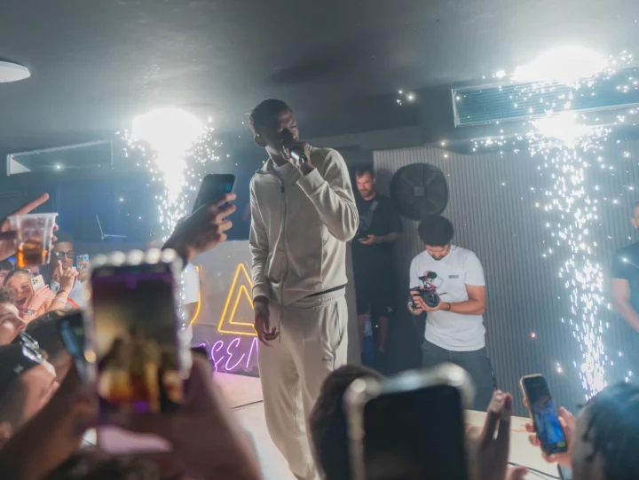 Artist performing on stage between indoor sparklers while the crowd records the set at Napa Xtra in Aqua Club