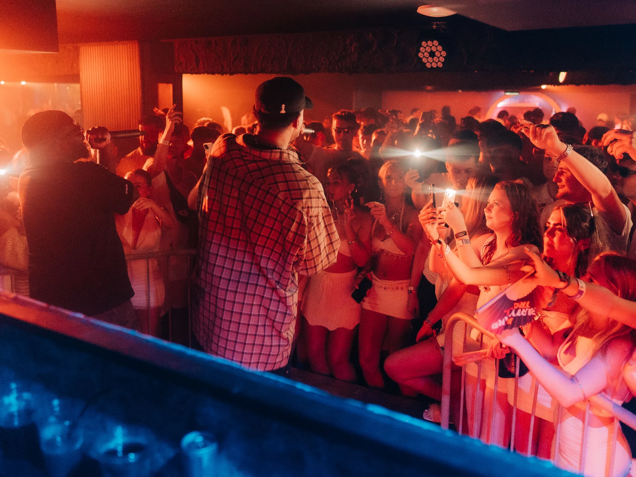 Two MCs performing in front of a packed crowd filming the set at Napa Xtra in Ayia Napa